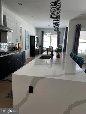 a large white kitchen with a large counter top appliances and cabinets