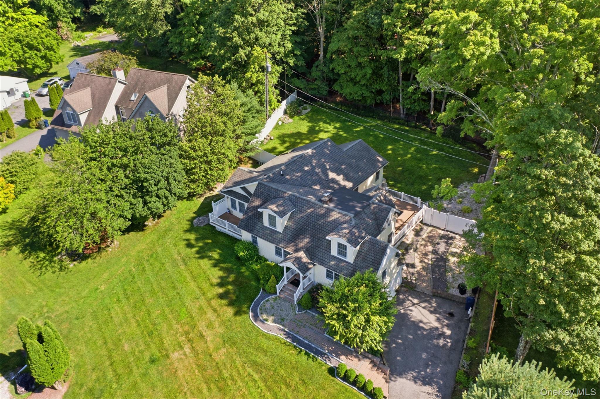 12 Leeside Road Carmel, NY 10512 - Photo 3 of 44 Expansive aerial perspective showcasing a residential property with a multi-level deck, a paved driveway, and mature landscaping