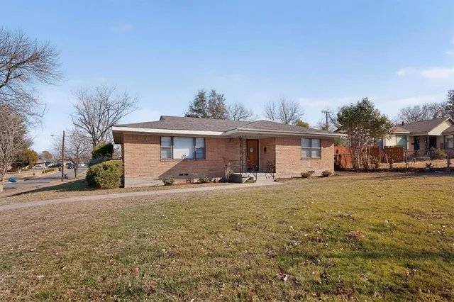 a front view of a house with a garden and trees