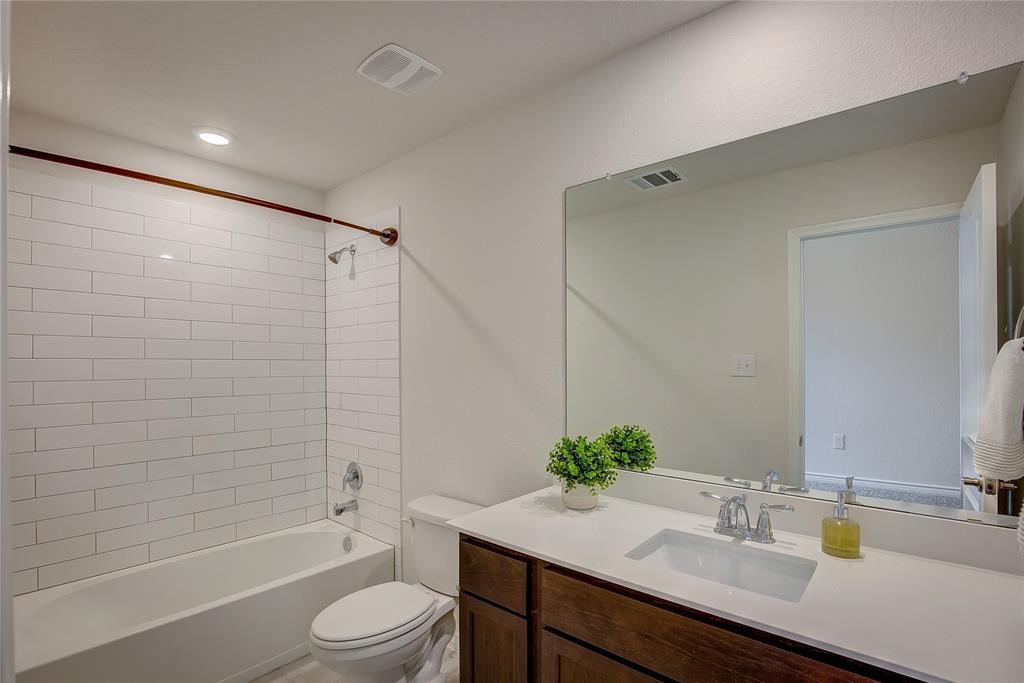 2703 Sayers Way Forney, TX 75126 - Photo 13 of 23 a bathroom with a granite countertop sink toilet a shower and a mirror
