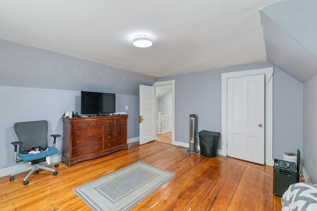 187 Highland Street Boston, MA 02119 - Photo 11 of 21 a bedroom with furniture and a flat screen tv