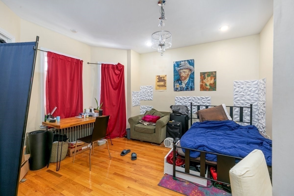 187 Highland Street Boston, MA 02119 - Photo 14 of 21 a bedroom with furniture and a bed