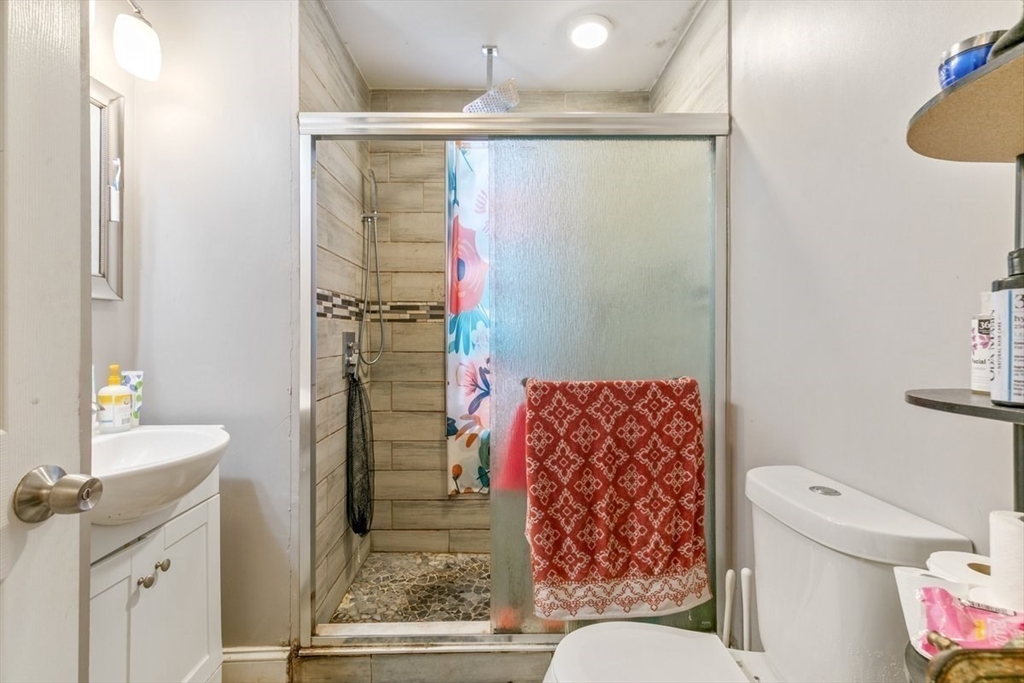 187 Highland Street Boston, MA 02119 - Photo 18 of 21 a bathroom with a shower curtain and a sink