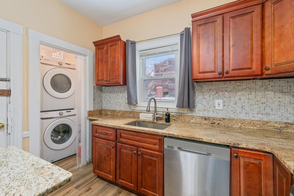187 Highland Street Boston, MA 02119 - Photo 2 of 21 a sink with granite countertop a sink and a washer dryer