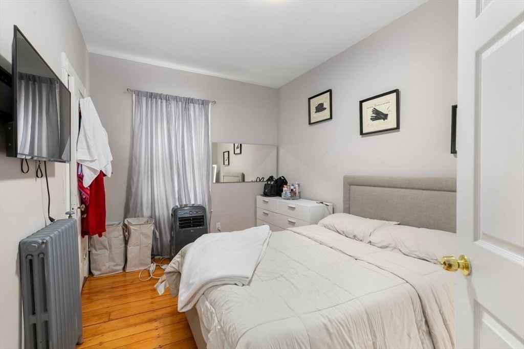 187 Highland Street Boston, MA 02119 - Photo 6 of 21 a bedroom with a bed and a window