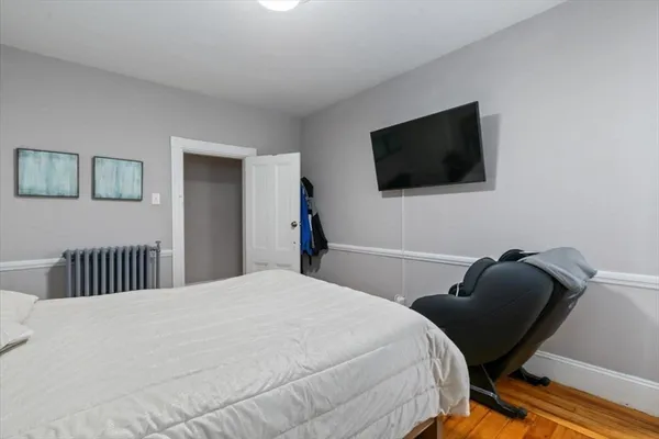 a bedroom with a bed chair and a window