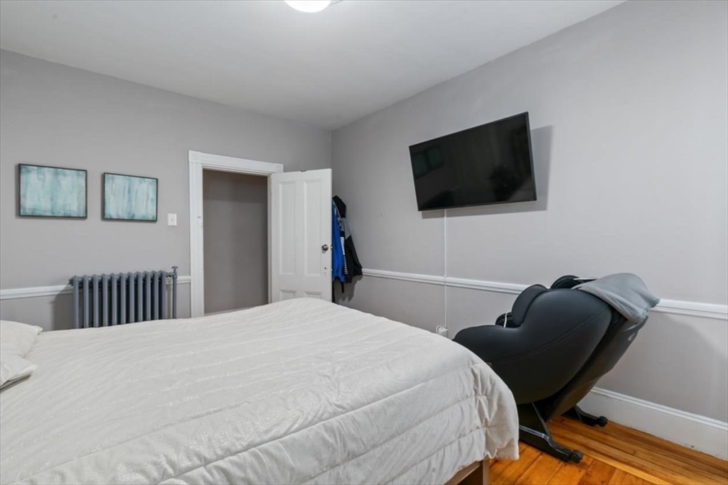187 Highland Street Boston, MA 02119 - Photo 8 of 21 a bedroom with a bed chair and a window