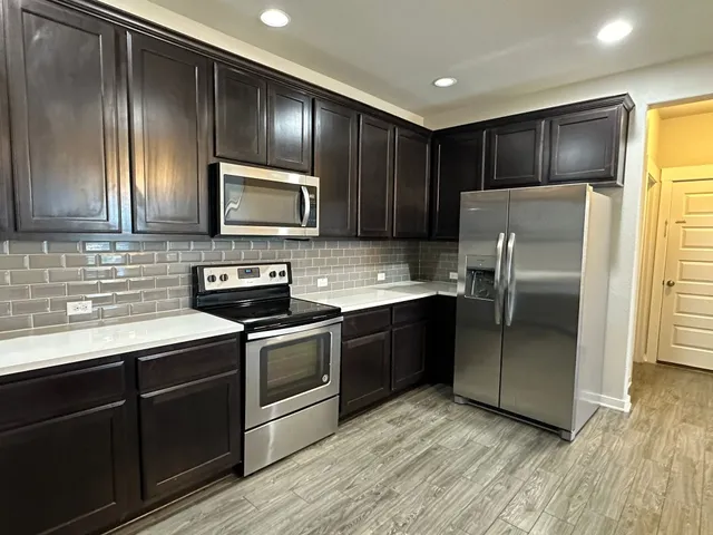 a kitchen with granite countertop stainless steel appliances and wooden cabinets