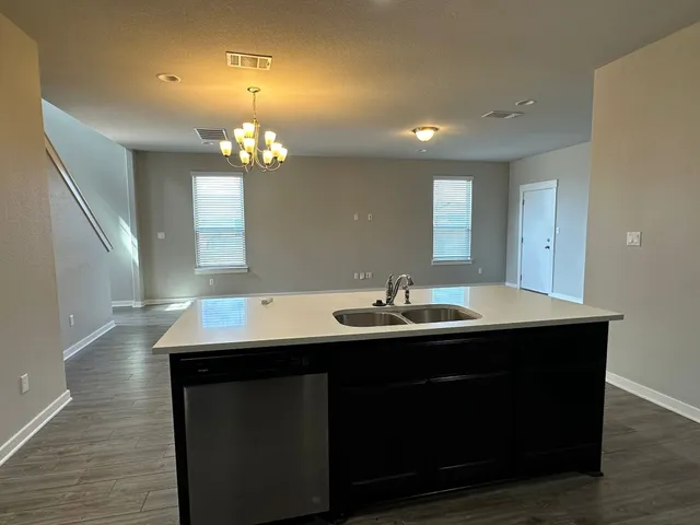 a kitchen with a sink cabinets and wooden floor