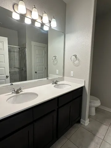 a bathroom with a double vanity sink and a toilet