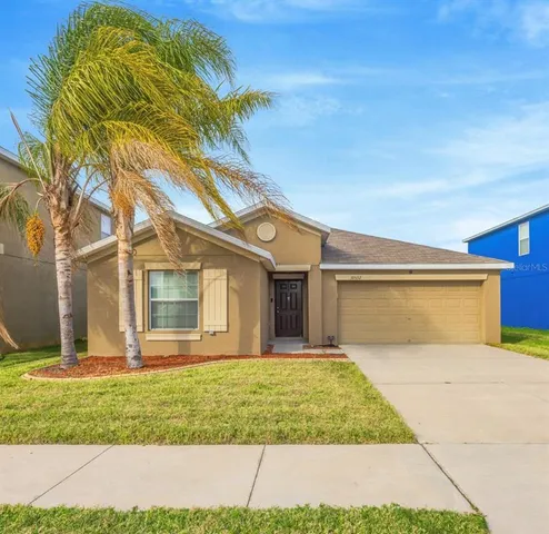 a front view of a house with a garden and yard