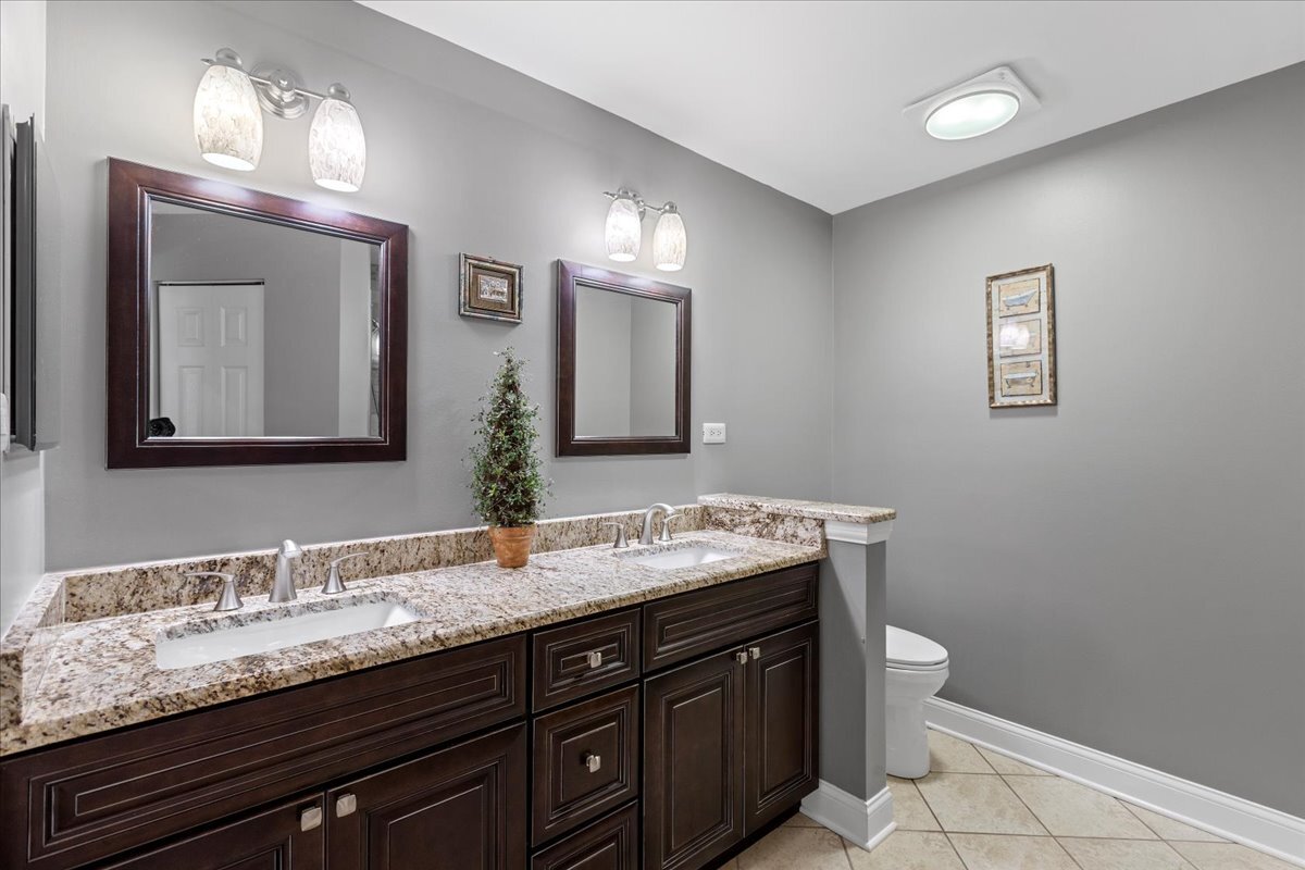 1636 Columbia Circle, Unit 2 Bartlett, IL 60103 - Photo 29 of 47 a bathroom with double vanity sinks a toilet and a mirror