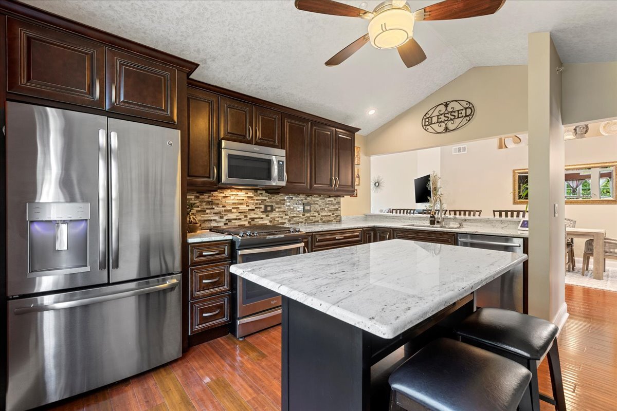 1636 Columbia Circle, Unit 2 Bartlett, IL 60103 - Photo 5 of 47 a kitchen with stainless steel appliances granite countertop a refrigerator a stove microwave and island