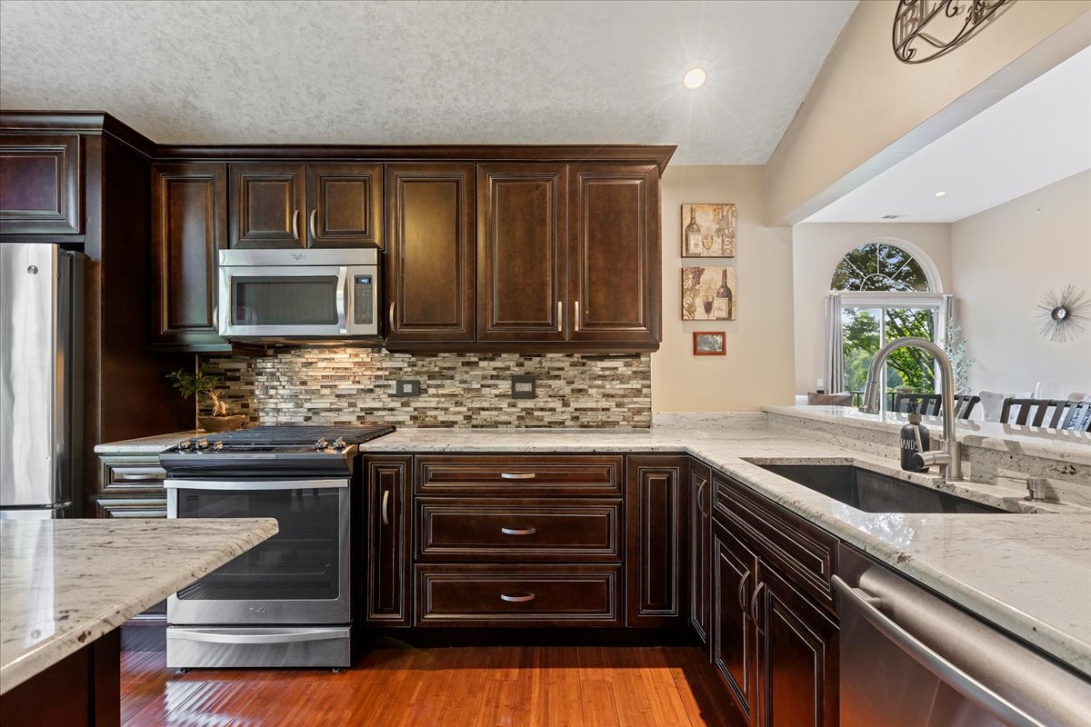 1636 Columbia Circle, Unit 2 Bartlett, IL 60103 - Photo 7 of 47 a kitchen with stainless steel appliances granite countertop a sink and cabinets