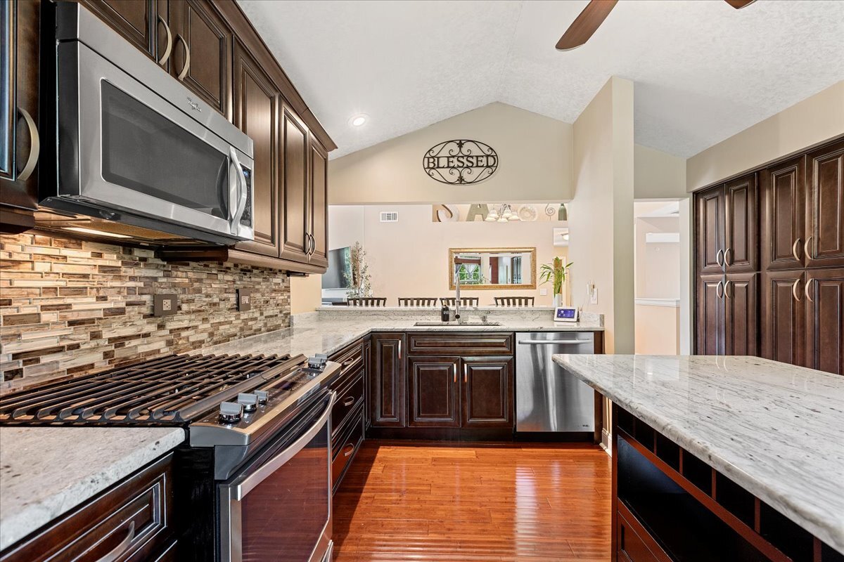 1636 Columbia Circle, Unit 2 Bartlett, IL 60103 - Photo 10 of 47 a kitchen with stainless steel appliances granite countertop a stove top oven microwave and cabinets
