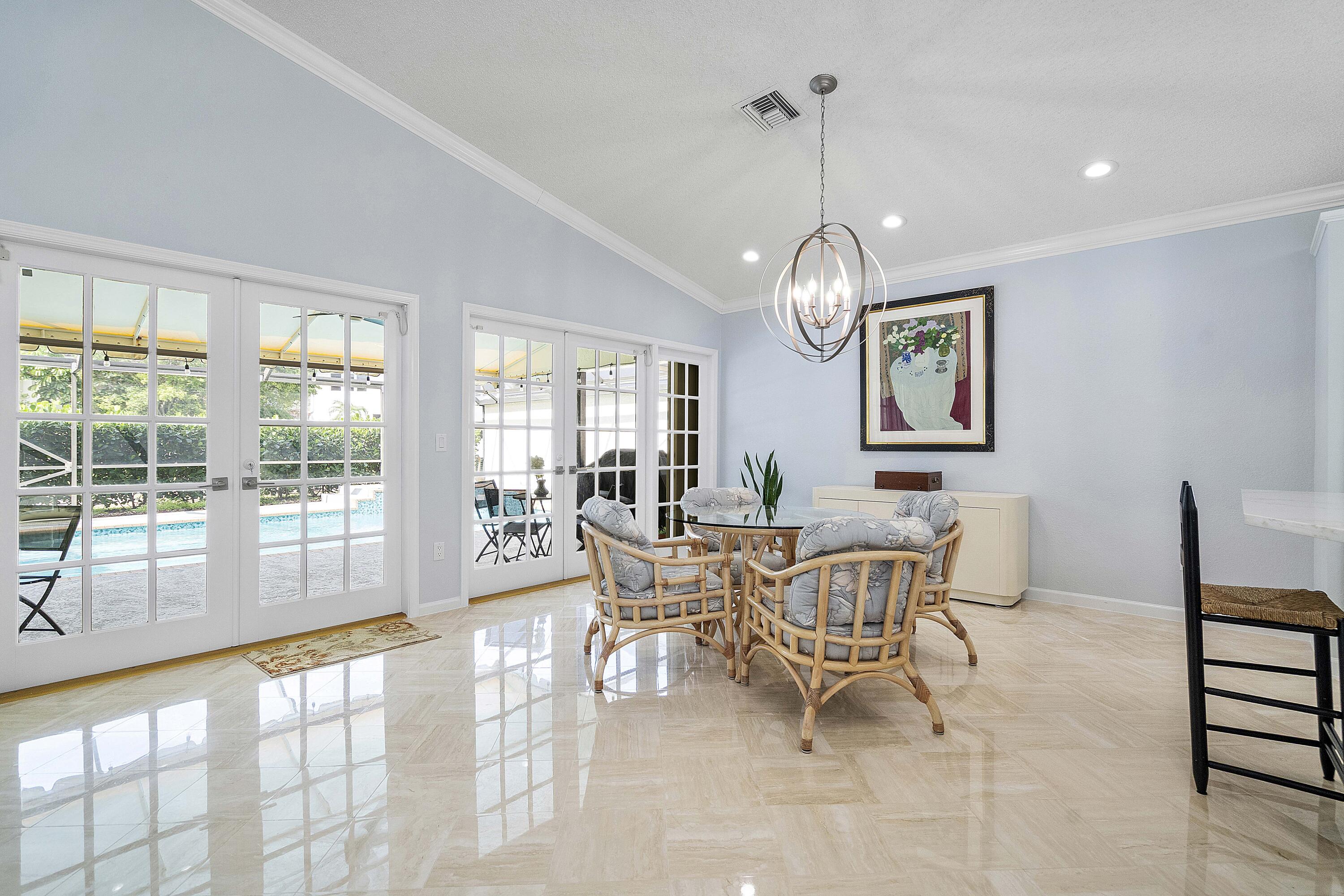 22652 Esplanada Circle Boca Raton, FL 33433 - Photo 32 of 44 a dining room with wooden floor a chandelier a glass table and chairs