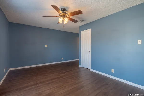 a view of an empty room with wooden floor
