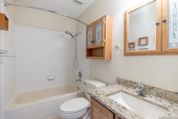a bathroom with a granite countertop sink toilet and shower