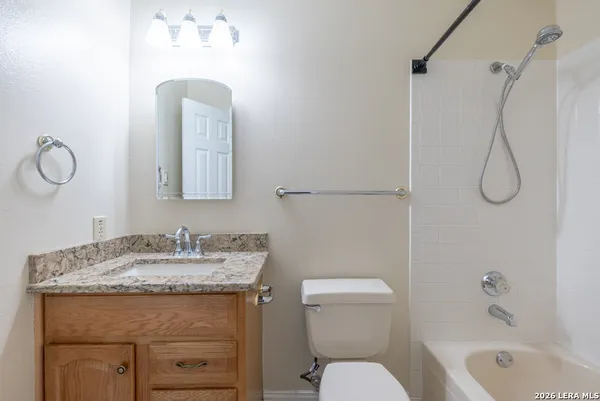 a bathroom with a granite countertop sink a toilet and a bathtub