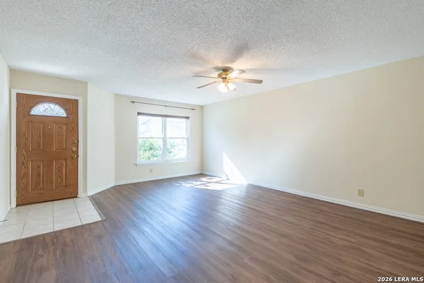 an empty room with wooden floor and windows