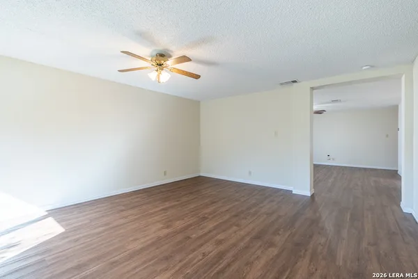 a view of a room with wooden floor and a ceiling fan