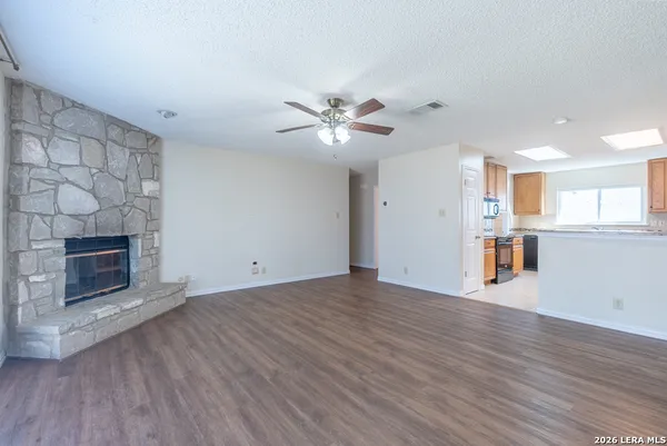 a view of an empty room with a fireplace and a window