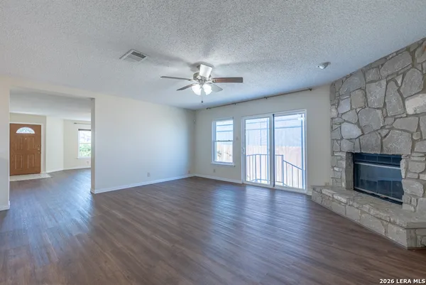 a view of an empty room with a fireplace and a window