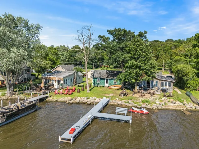 an aerial view of a house with swimming pool and lake view
