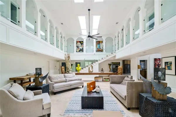 a living room with furniture kitchen view and a chandelier