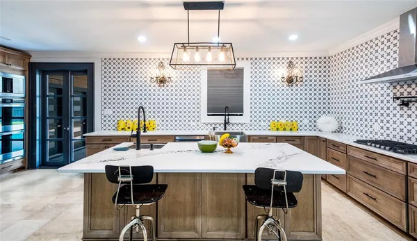 a kitchen with stainless steel appliances kitchen island granite countertop a table and chairs in it