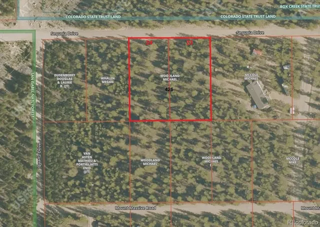 a view of a field with plants and wooden fence