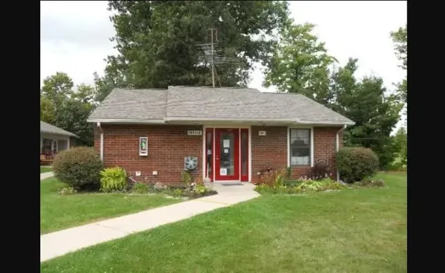 a front view of a house with a garden and plants