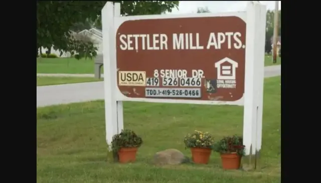 a sign that is sitting on a brick wall