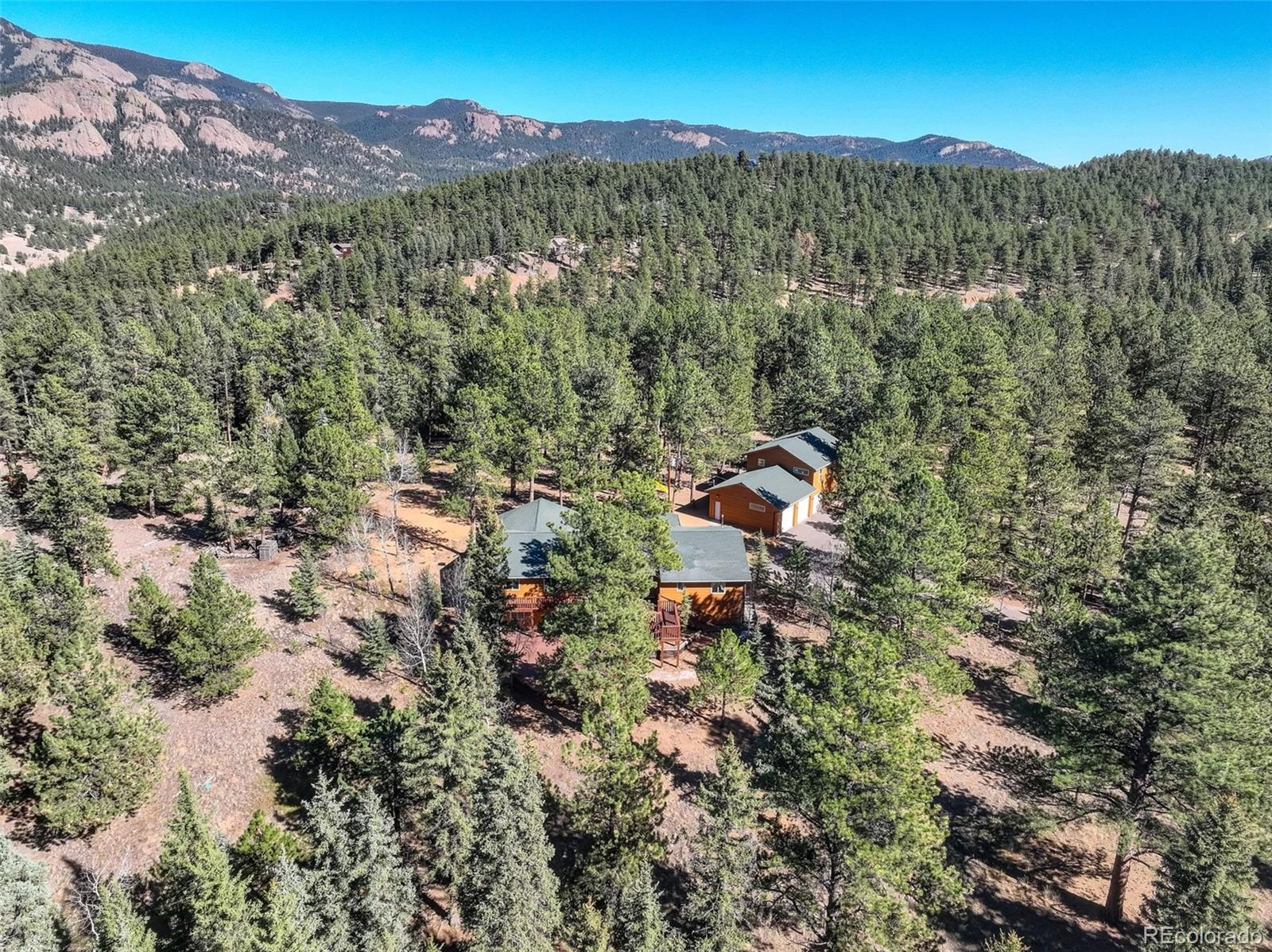 225 Spring Drive Pine, CO 80470 - Photo 1 of 44 a view of a forest with mountains in the background