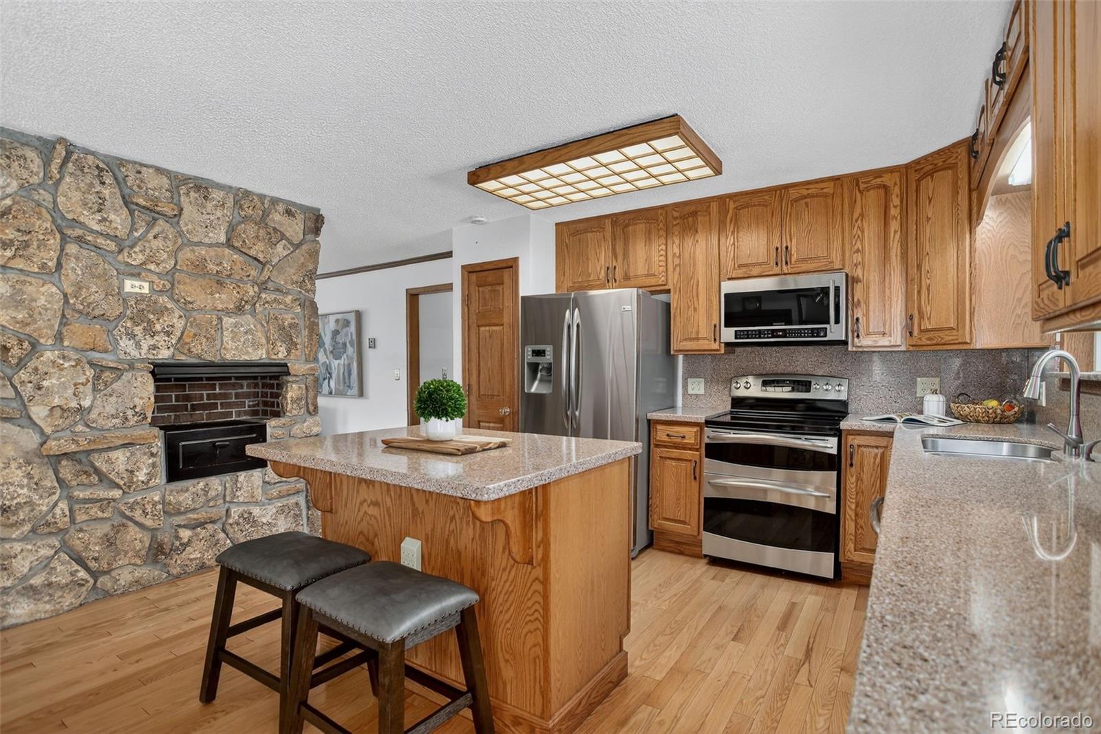 225 Spring Drive Pine, CO 80470 - Photo 15 of 44 a kitchen with stainless steel appliances a stove a sink refrigerator and a microwave