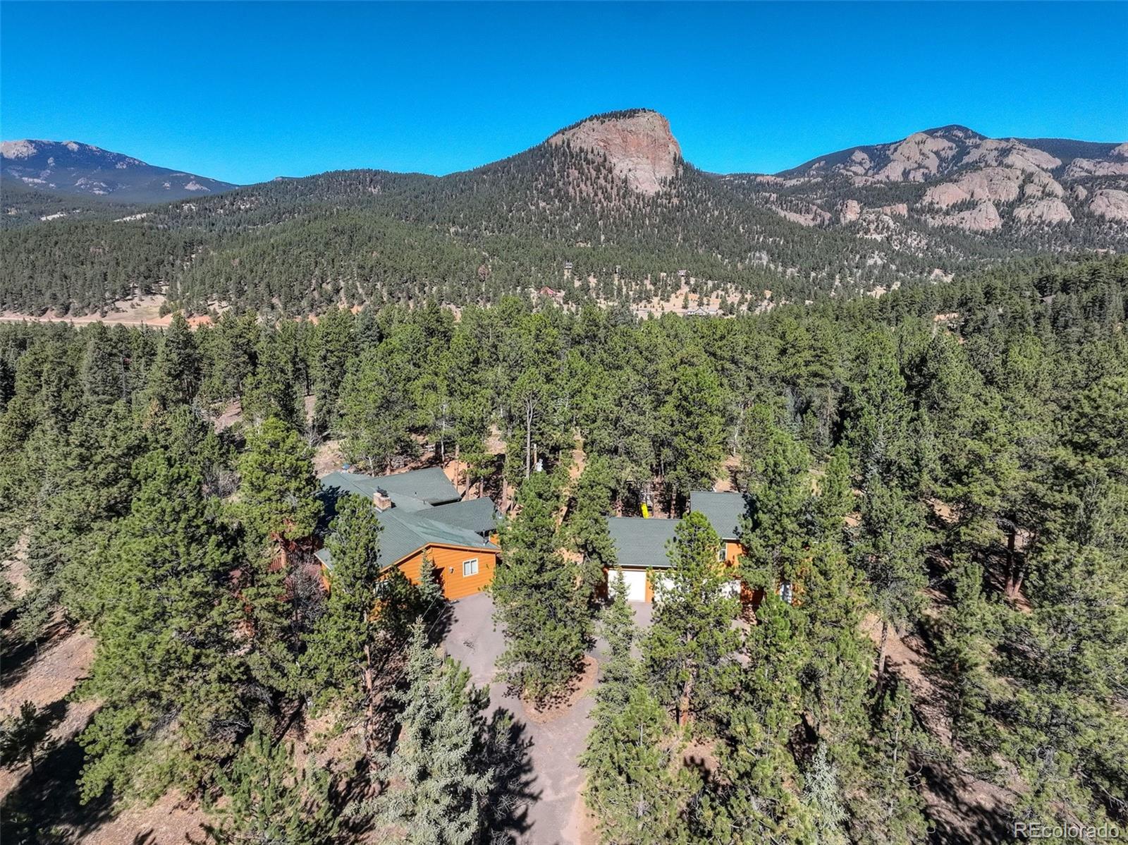 225 Spring Drive Pine, CO 80470 - Photo 2 of 44 a view of a house with a mountain in the background