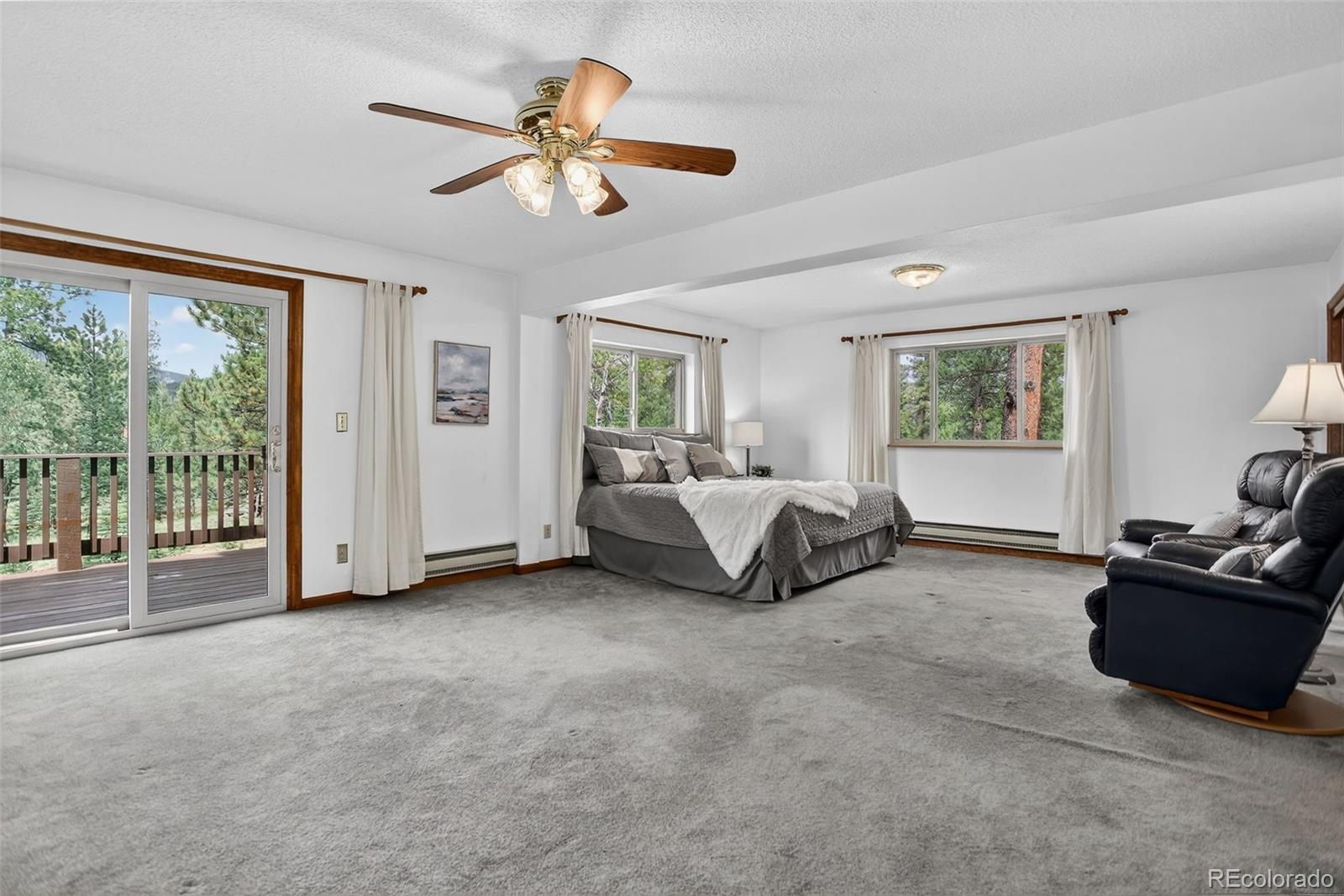 225 Spring Drive Pine, CO 80470 - Photo 9 of 44 a spacious bedroom with a bed and a couch