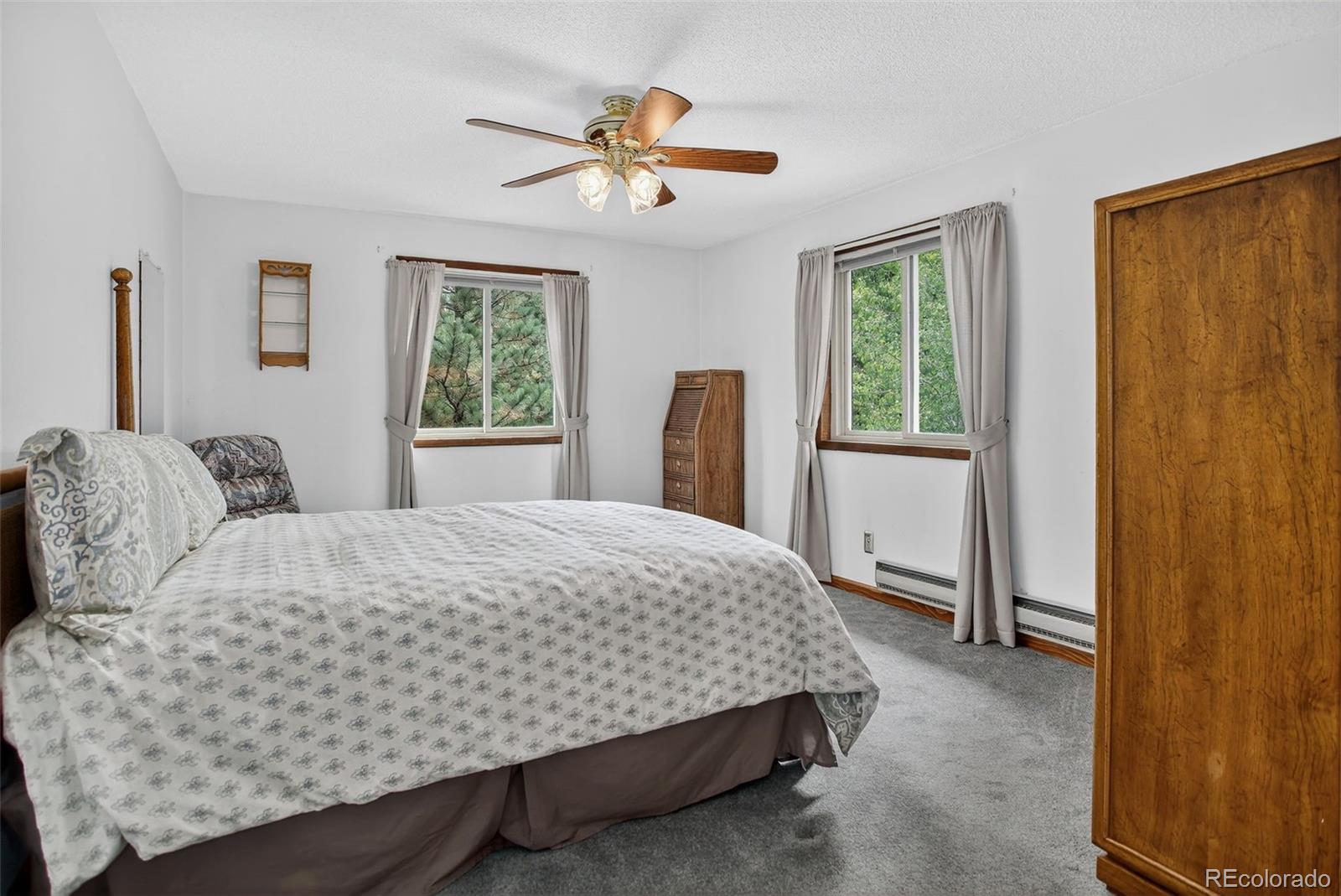 225 Spring Drive Pine, CO 80470 - Photo 10 of 44 a bedroom with a large bed and a chandelier