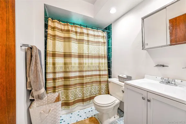 a bathroom with a sink a toilet and shower curtain
