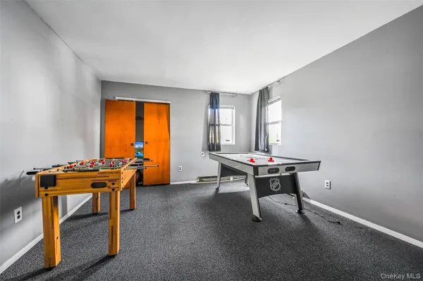 a room with furniture pool table and windows