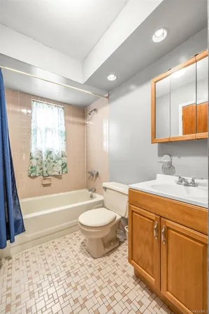 a bathroom with a granite countertop sink toilet mirror and bathtub