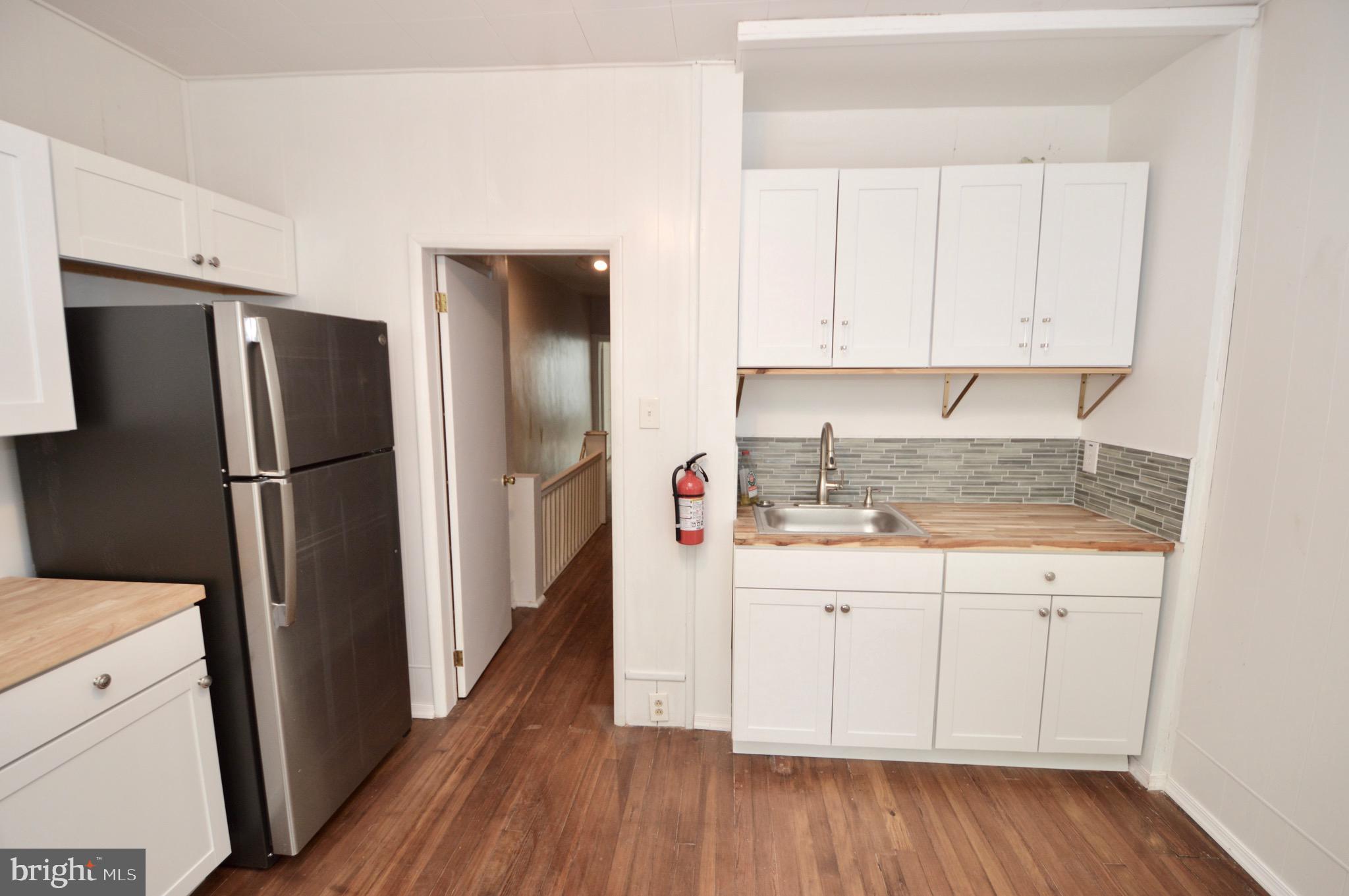 609 White Horse Pike Haddon Township, NJ 08107 - Photo 12 of 17 a kitchen with a refrigerator a sink and wooden floor