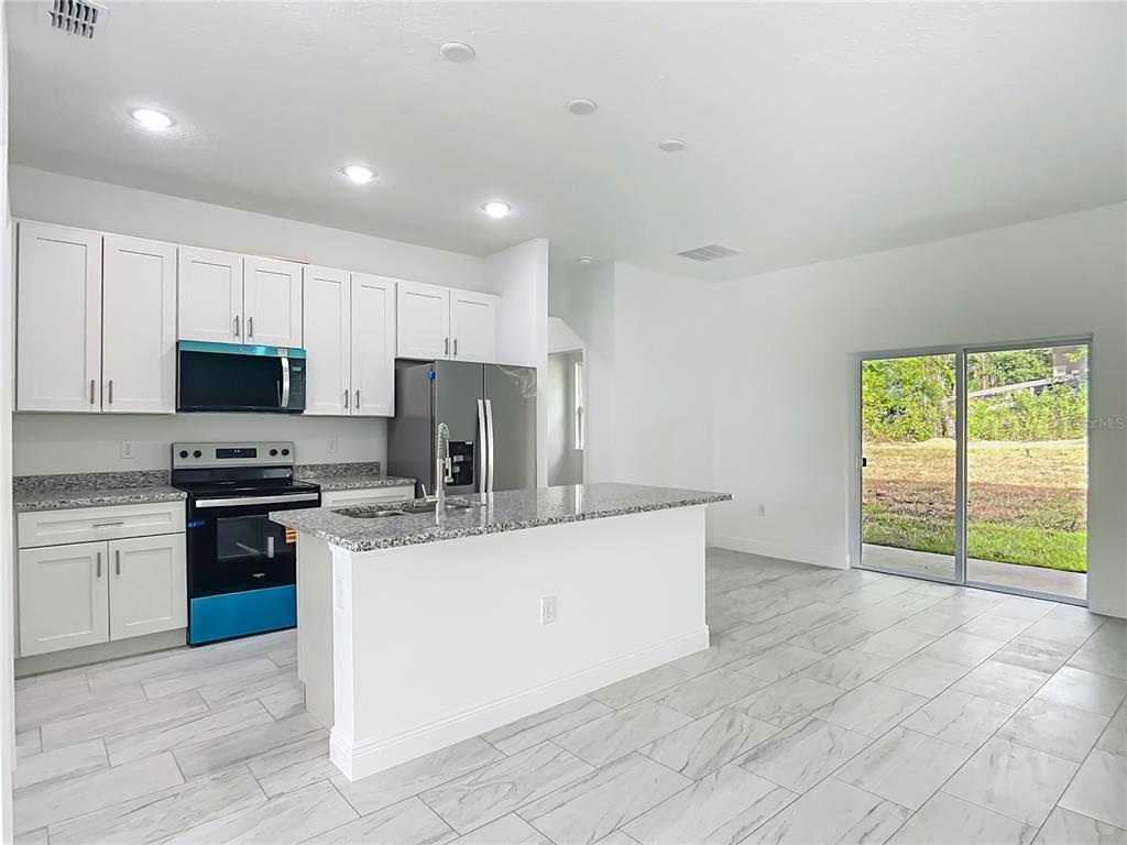 5736 North Claremont Drive Citrus Springs, FL 34434 - Photo 16 of 45 a kitchen with stainless steel appliances granite countertop a stove a sink and a refrigerator