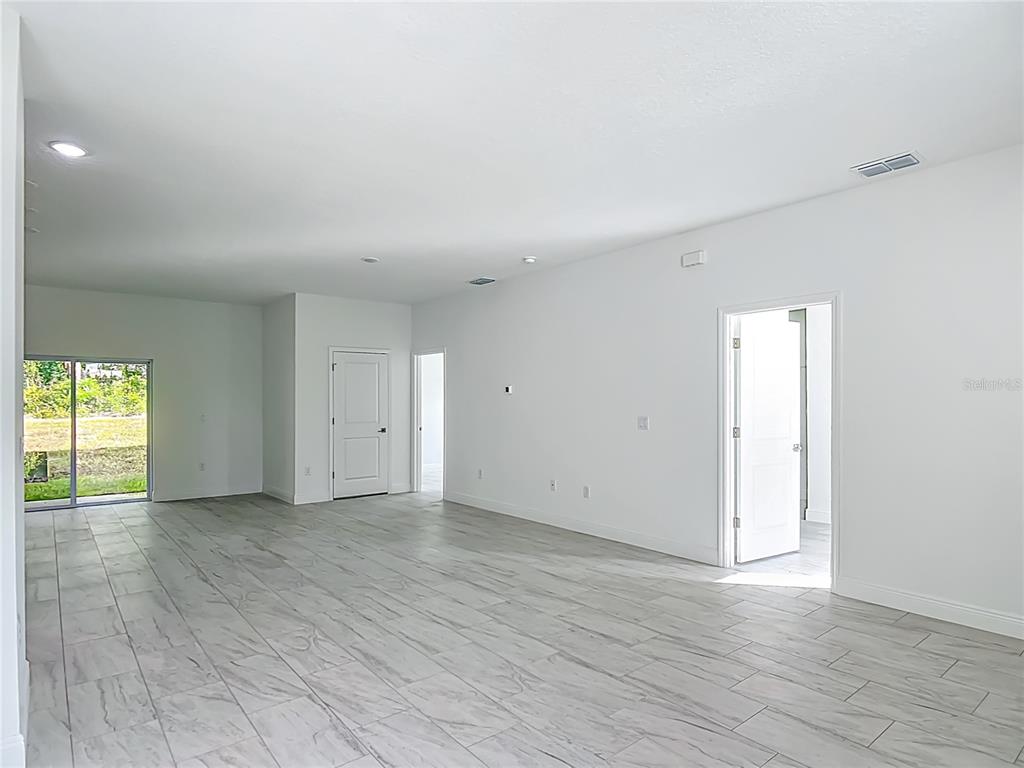 5736 North Claremont Drive Citrus Springs, FL 34434 - Photo 17 of 45 an empty room with wooden floor and windows