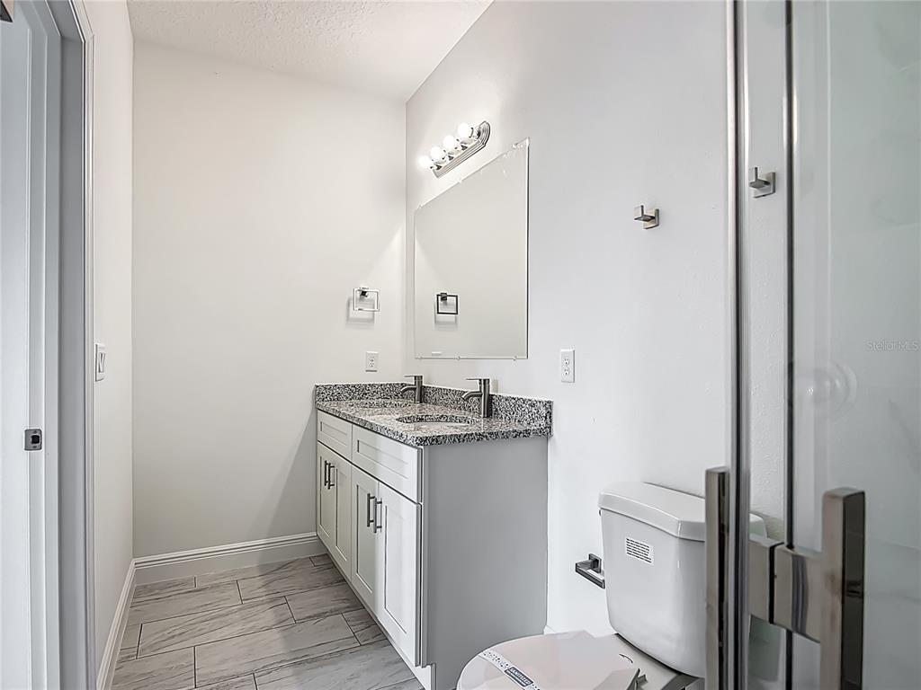 5736 North Claremont Drive Citrus Springs, FL 34434 - Photo 27 of 45 a bathroom with a granite countertop sink a toilet and a mirror