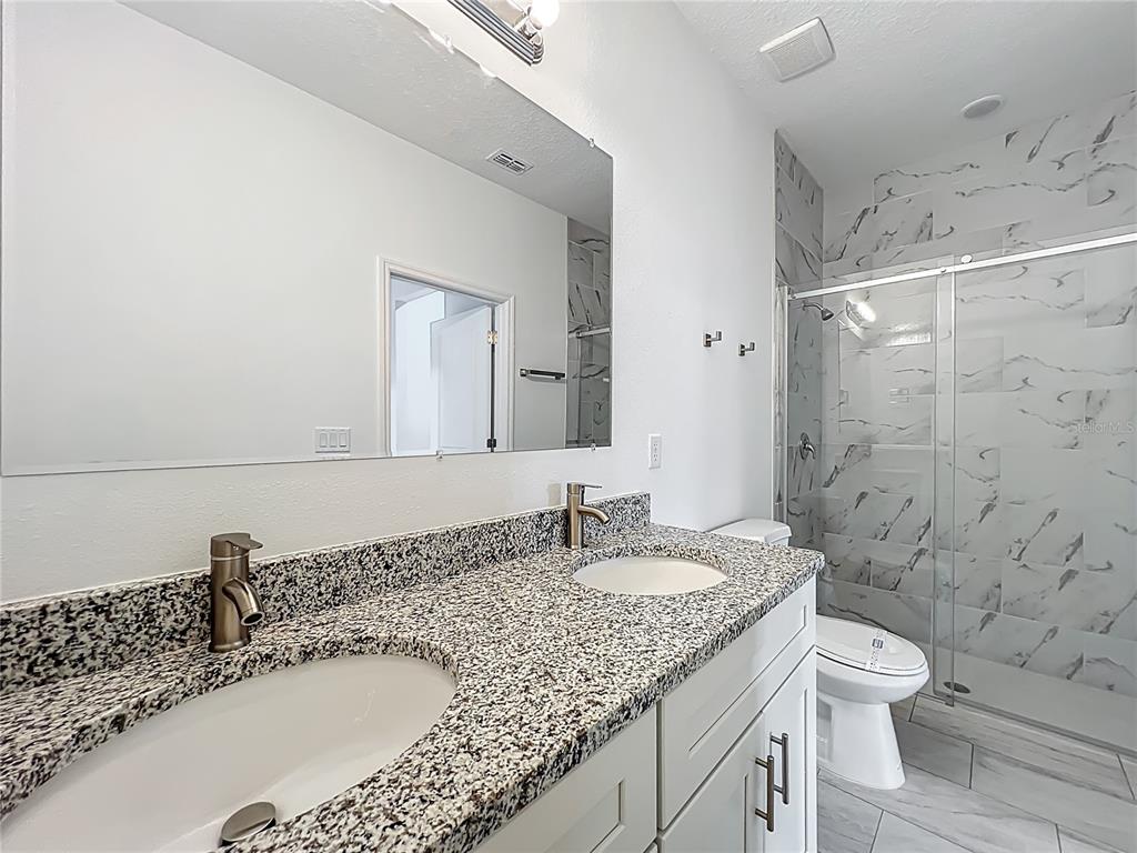 5736 North Claremont Drive Citrus Springs, FL 34434 - Photo 28 of 45 a bathroom with a granite countertop sink a toilet and shower