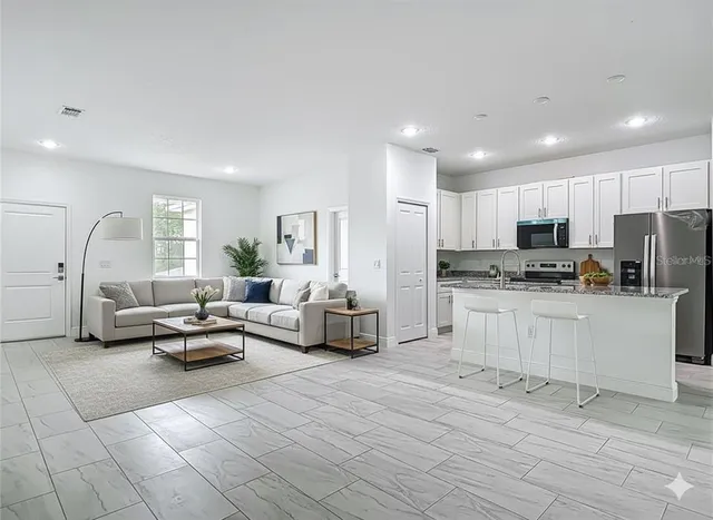 a kitchen with stainless steel appliances granite countertop a refrigerator a stove a sink and a microwave