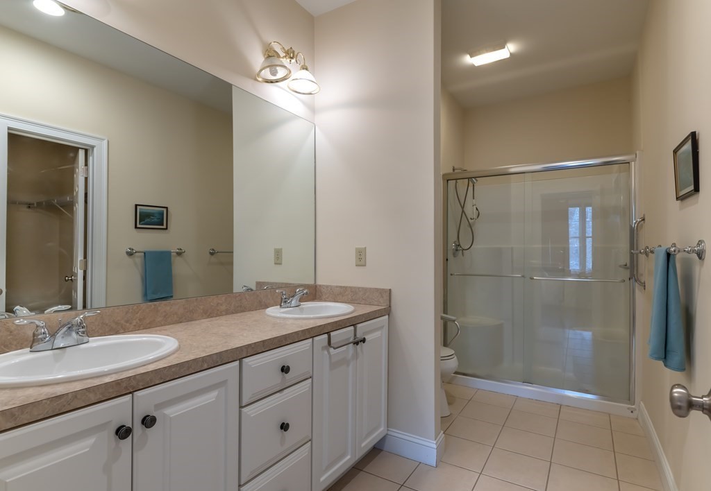 359 Main Street, Unit 15A Easthampton, MA 01027 - Photo 15 of 24 a bathroom with a granite countertop sink a mirror and a shower