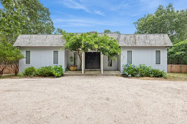 a front view of a house with a garden and plants
