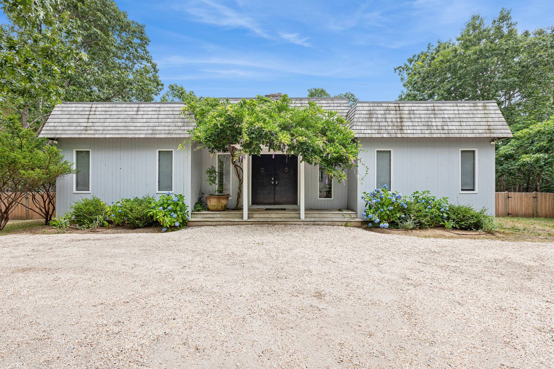 a front view of a house with a garden and plants